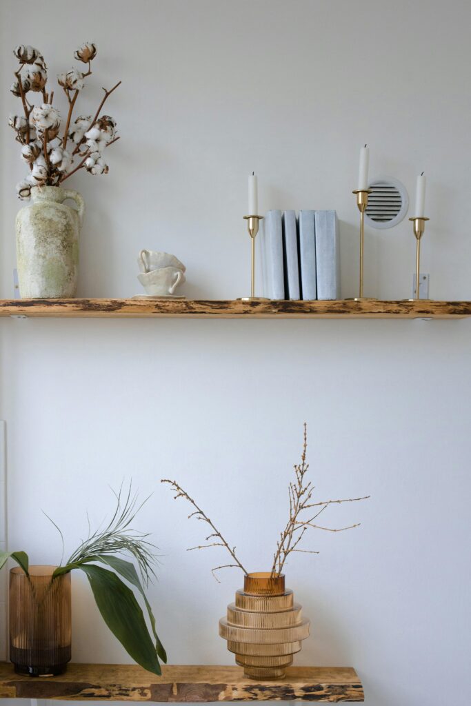 Explore minimalist decor with wooden shelves, candles, and botanical elements.